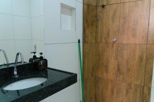 a bathroom with a sink and a wooden door at Pousada Vasconcelos Tianguá in Tianguá +80 photos