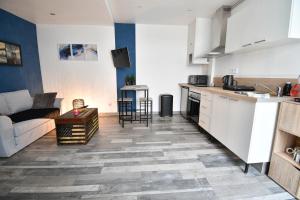 a kitchen and living room with a couch and a table at République Le Nid Douillet in Saint-Dizier