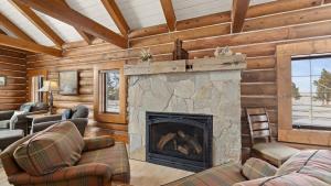 a living room with a fireplace in a log cabin at Grizzly Peak Cabin in Red Lodge
