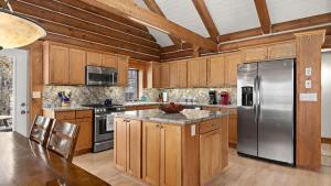 a kitchen with wooden cabinets and a stainless steel refrigerator at Grizzly Peak Cabin in Red Lodge +40 photos