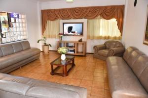 a living room with two couches and a television at Santa Maria Hotel in Cascavel +3 photos