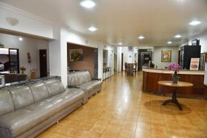 a large living room with a couch and a table at Santa Maria Hotel in Cascavel