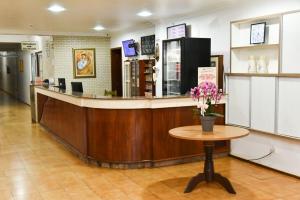 a bar in a store with a table and flowers at Santa Maria Hotel in Cascavel
