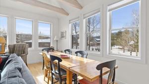 a dining room with a table and chairs and windows at Mountain Treetop in Red Lodge