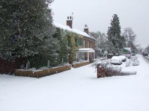 a yard covered in snow in front of a house at Andel Lodge & Restaurant in King's Lynn