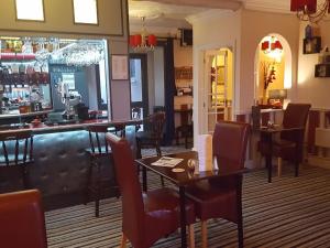 a restaurant with tables and chairs and a bar at Andel Lodge & Restaurant in King's Lynn +1 photo