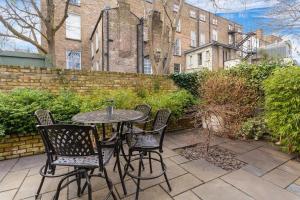 a patio with a table and chairs and a brick building at Spectacular 2 Bedroom Apartment with Sunny Garden & Terrace in Dublin