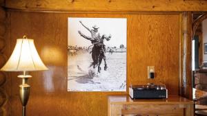a painting of a cowboy on a horse on a wall at Rendezvous Lodge in Red Lodge