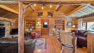 a log cabin living room with leather furniture and a fireplace at Rendezvous Lodge in Red Lodge +46 photos