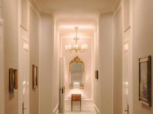 a hallway in a home with a chandelier at Fairmont Hotel Vier Jahreszeiten in Hamburg