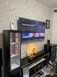 a tv screen on a wall with a shelf at Neriah Paradise in Gatunga