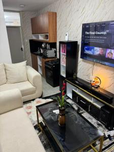 a living room with a couch and a flat screen tv at Neriah Paradise in Gatunga