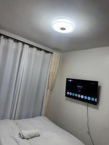 a bedroom with a bed with a television on the wall at Neriah Paradise in Gatunga