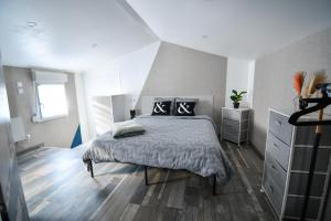 a bedroom with a bed and a dresser at République Le Nid Douillet in Saint-Dizier