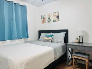 a bedroom with a bed with blue curtains and a desk at Cozy Stay Retreat in Fairbanks