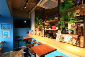 a bar with tables and chairs in a restaurant at ゲストハウス&café chiuwo in Kawazu