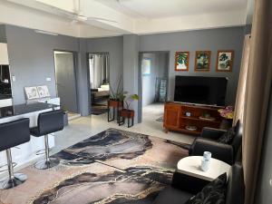 a living room with a couch and a tv at Athaliah Stays in Suva