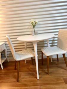a white table with two chairs and a vase with flowers at Romantic Couples Retreat in Mount Tamborine +26 photos