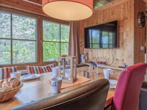 a dining room with a table with chairs and a television at im Brixental II in Wörgl