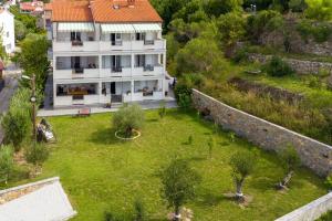 an aerial view of a house with a yard at Apartments and rooms by the sea Palit, Rab - 5044 in Rab