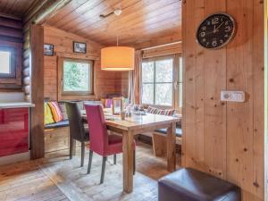 a dining room with a table and chairs and a clock at im Brixental II in Wörgl