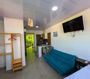 a living room with a blue couch and a tv at Sukha Hippocampus San Andrés Isla in San Andrés