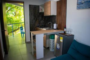 a kitchen with a counter with a sink and a table at Sukha Hippocampus San Andrés Isla in San Andrés