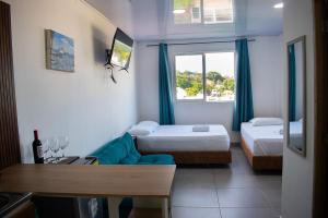 a room with two beds and a couch and a window at Sukha Hippocampus San Andrés Isla in San Andrés +75 photos