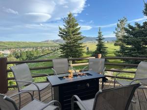a patio with chairs and a fire pit on a deck at Spruce Lodge in Red Lodge