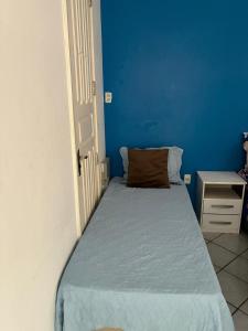 a small bedroom with a bed and a blue wall at Casa Nossa Senhora de Nazaré 2 in Belém +5 photos