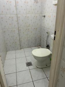 a bathroom with a toilet and a tiled floor at Casa Nossa Senhora de Nazaré 2 in Belém