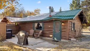 a log cabin with a green door and a bench at Wild Bills Cabin in Red Lodge