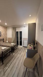 a room with two beds and a desk and a chair at Affittacamere Casa Lucia in La Spezia