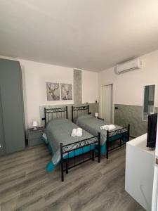 a bedroom with two beds and a tv in it at Affittacamere Casa Lucia in La Spezia