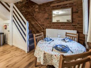 a dining room with a table and a staircase at Yarlington Mill in Ledbury