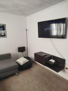 a living room with a couch and a flat screen tv at Casita de descanso in Pueblo Esther