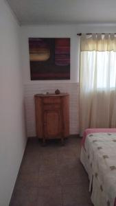 a bedroom with a bed and a table and a window at Casita de descanso in Pueblo Esther