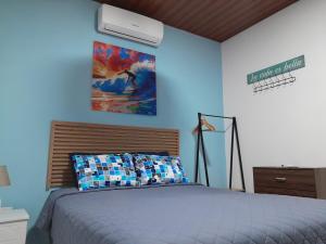 a bedroom with a bed and a painting on the wall at EL sunzal Bliss #8 in El Sunzal