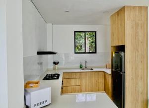 a kitchen with wooden cabinets and a black refrigerator at Villa Sierra Mar in Playa Bello Horizonte