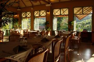 a dining room with tables and chairs and windows at Lost Horizon Resort - Khao Sok in Khao Sok National Park