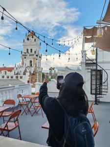a person taking a picture of a white lighthouse at Hostal Distrito in Sucre