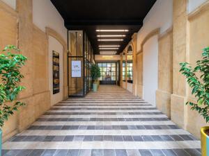 a hallway of a building with a tile floor at Mercure Grand Hôtel Metz Centre Cathédrale in Metz