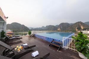 a balcony with chairs and a swimming pool with mountains in the background at Tam Coc Sunshine Villa in Vũ Lâm