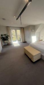 a large bedroom with a bed and a large window at Layla Grove in Grove Park
