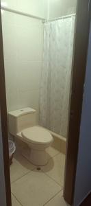 a white bathroom with a toilet and a shower at AMARU Palace in Machu Picchu