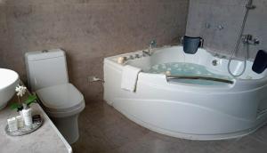 a bathroom with a tub with a toilet and a sink at Casa Blanca Andina in Cajamarca