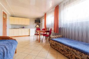 a bedroom with a bed and a table and a kitchen at OW Wilk - pokoje i domki z aneksami kuchennymi, parking, plac zabaw in Łeba