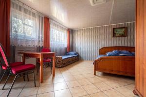 a bedroom with a bed and a desk and a table at OW Wilk - pokoje i domki z aneksami kuchennymi, parking, plac zabaw in Łeba