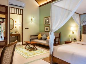 a bedroom with a bed and a couch at Lost Horizon Resort - Khao Sok in Khao Sok National Park