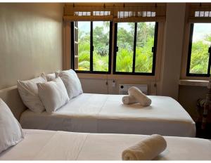 two beds in a room with two windows at Stefanie Grace Inn in Loboc